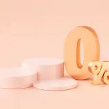 Złote cyfry "0%" na pastelowym tle, obok okrągłych podium. Idealna oferta na raty 0%.