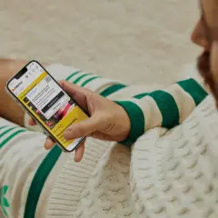 Mężczyzna przegląda telefon z aplikacją Zalando. Widoczna promocja: zalando - 15% na wszystko.