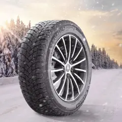 Opona zimowa Michelin X-Ice Snow 215/55R17 na tle zaśnieżonego lasu. Sprawdź nasz ranking opon zimowych!
