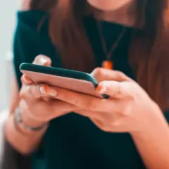 Kobieta pisze na telefonie, planując zakupy na Vinted z opcją PayPo.