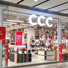 CCC - promocje w sklepach stacjonarnych. W witrynie sklepu CCC widoczne są wyprzedaże -20% i -50% na obuwie i torebki.