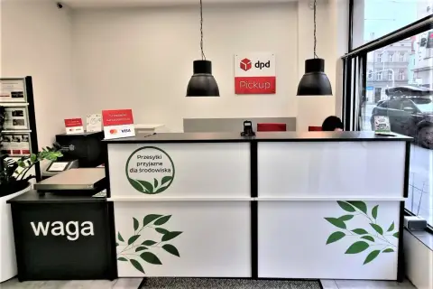 Punkt dpd KTW z zielonym logo "Przesyłki przyjazne dla środowiska". Waga i terminal płatniczy na ladzie.