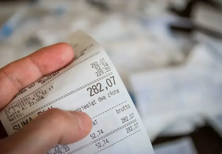 Dłoń trzyma rachunek za paliwo. Suma to 282,07 zł. Czy to będzie zwrot bez paragonu?