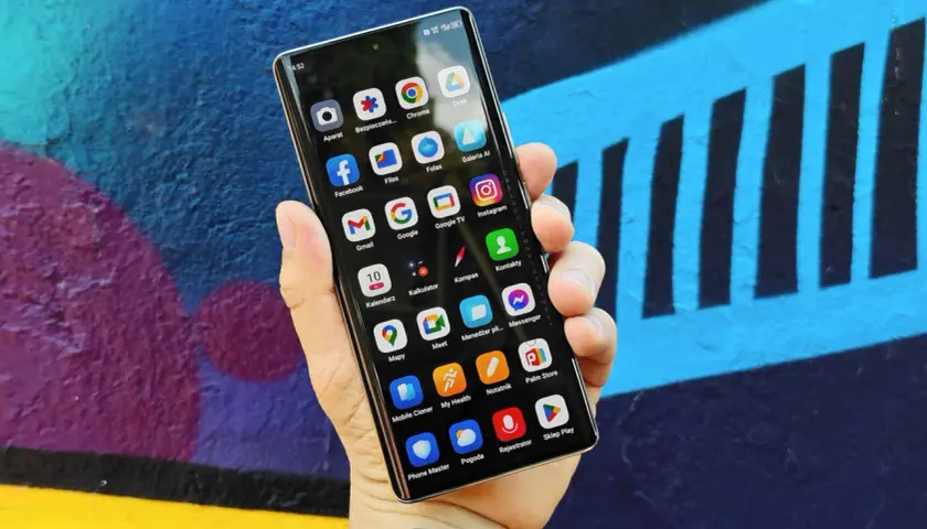 Smartfon z kolorowym tłem. Na ekranie widoczne ikony aplikacji, pomocne przy tworzeniu rankingu telefonów do 1500.