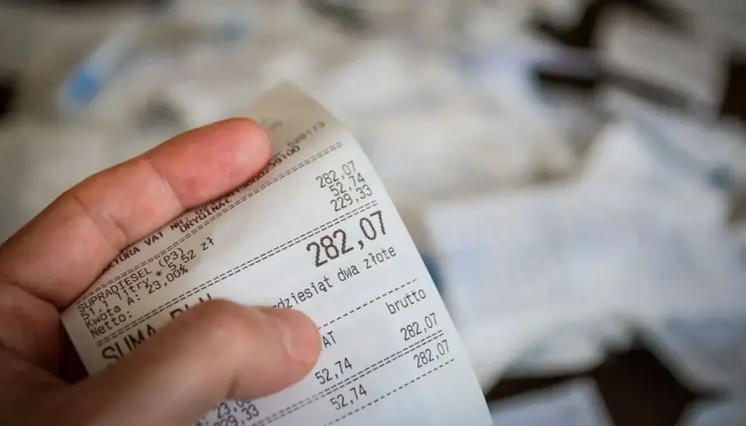 Dłoń trzyma rachunek za paliwo. Suma to 282,07 zł. Czy to będzie zwrot bez paragonu?
