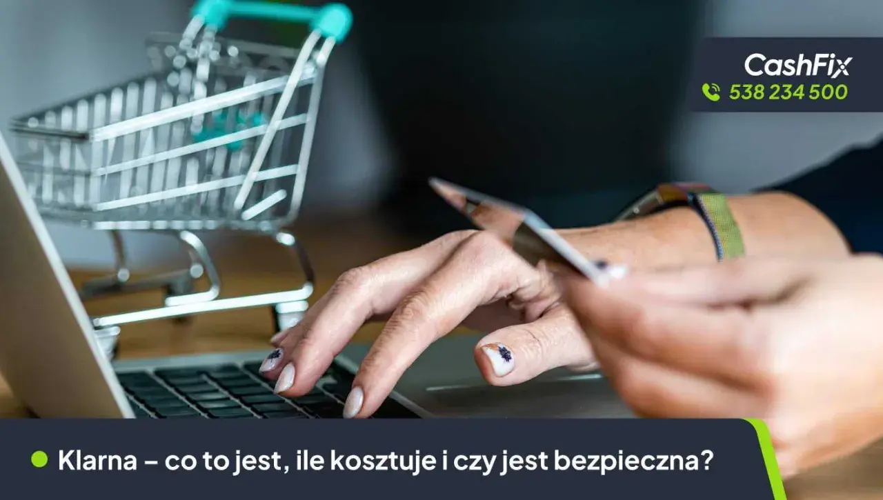 Dłoń trzyma kartę płatniczą nad klawiaturą laptopa, obok miniaturowy wózek sklepowy. Temat: karta Klarna.