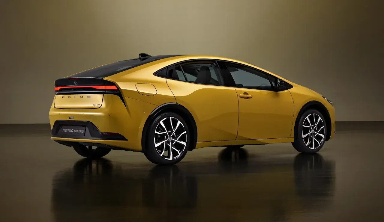 Złoty Prius Plug-in Hybrid, jeden z ekologicznych samochodów, prezentuje swój nowoczesny design z tyłu.