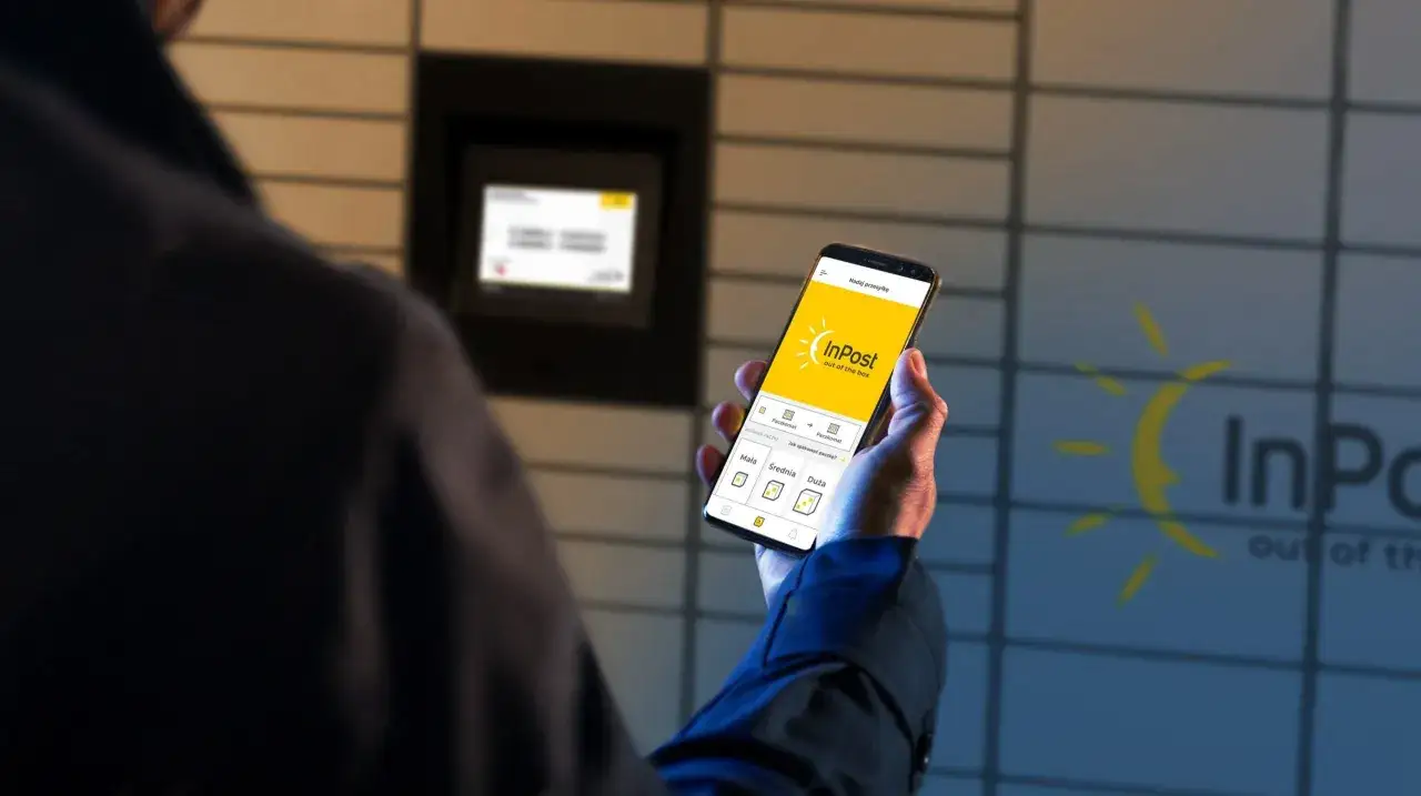 Mężczyzna trzyma smartfon z aplikacją InPost, planując nadanie paczki. Widoczny Paczkomat sugeruje szybkie zwroty.