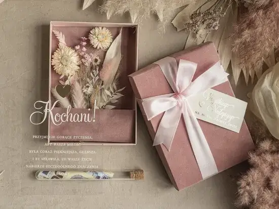 kobieta otrzymująca prezent, uśmiechnięta para, eleganckie pudełko prezentowe